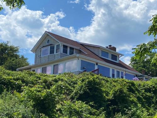 a house on top of a hill with bushes at Chesapeake Bay Maryland Waterfront Home, Stunning Views 45 min from DC pier fossils hiking in Port Republic