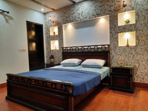 a bedroom with a bed with a large mirror on the wall at Furnished Luxury Holiday and Vacation Home in Lahore