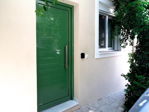 uma porta verde ao lado de uma casa em Twin Lofts Πολυχάρους, a KalamataStay Property em Kalamata