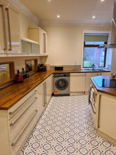 een keuken met een wasmachine en een wasmachine bij Stunning River View in Mytholmroyd
