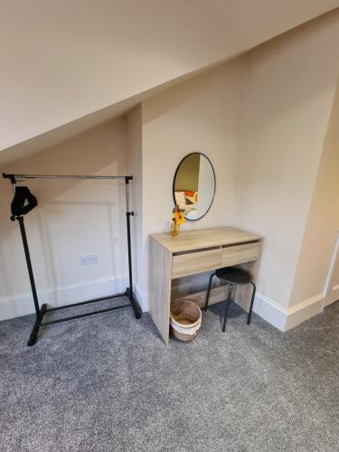 a desk with a mirror and a chair in a room at Spacious Mytholmroyd Apartment with River Views in Mytholmroyd
