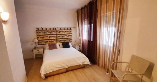 a bedroom with a bed and a chair in it at Estepona playa in Estepona