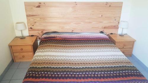 un lit avec une tête de lit en bois et deux lampes dans l'établissement Résidence Parc Et Avenue Dominica - 2 pièces au rez-de-chaussée à LE BARCARES - CAP COUDALERE MAE-8324, au Barcarès