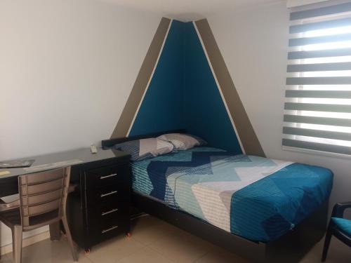 1 dormitorio con cama y escritorio en Hospédate cerca al aeropuerto Matecaña en Pereira