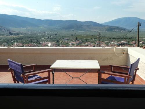 a table and two chairs on a balcony with a view at Villa Rastoni in Áyios Andréas Arkadias