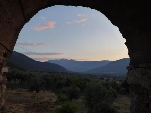 a view of the mountains from a stone window at Villa Rastoni in Áyios Andréas Arkadias