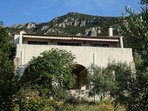 a building with a mountain in the background at Villa Rastoni in Áyios Andréas Arkadias
