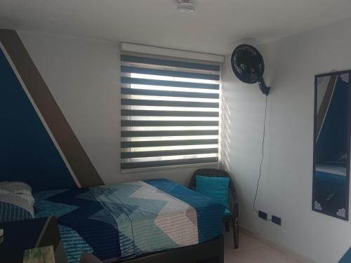 1 dormitorio con 1 cama y ventana con persianas en Hospédate cerca al aeropuerto Matecaña en Pereira