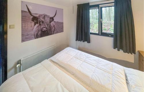 Lovely stacaravan In Zeeland With Wifi في زيلاند: غرفة نوم بسرير وصورة ثور على الحائط