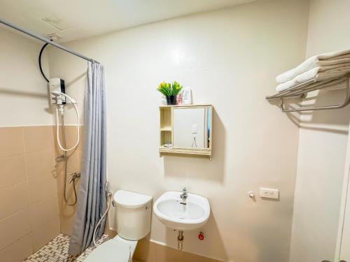 ein Bad mit einem WC, einem Waschbecken und einer Dusche in der Unterkunft THE LOOP 2br fully furnished corner unit w balcony in Cagayan de Oro
