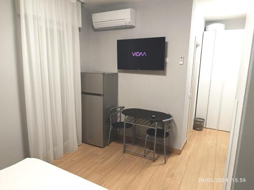a room with a table and a tv on the wall at Residenza delle Nazioni in Gatteo a Mare