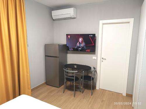 a small room with a table and a tv on the wall at Residenza delle Nazioni in Gatteo a Mare