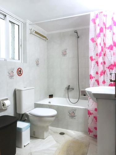 een badkamer met een toilet, een bad en een wastafel bij Central Family Apartment in Preveza
