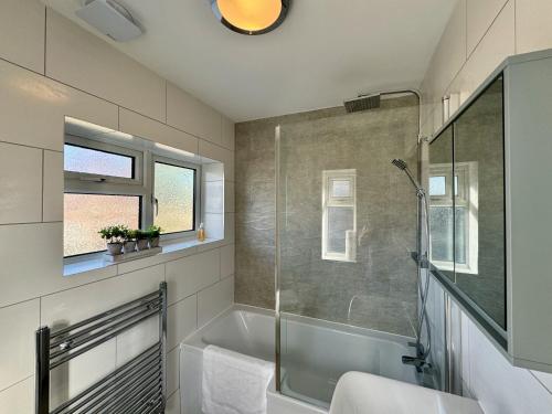 a bathroom with a shower and a bath tub at Sandringham House - Serene Escape Cottage in Cleethorpes