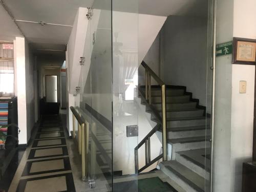 a hallway with stairs and a glass wall at QUÉDATE CON NOSOTROS EN EL QUINDÍO in Armenia