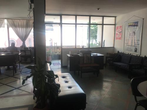 uma sala de estar com sofás, mesas e janelas em QUÉDATE CON NOSOTROS EN EL QUINDÍO em Armênia