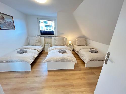 a room with two beds and a window at JAVU Restaurant & FeWo in Iserlohn