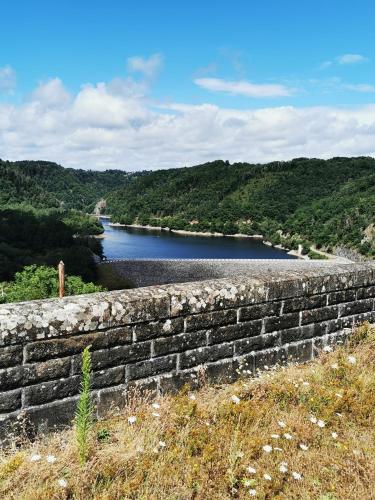 a stone wall next to a body of water at Gîte du Domaine des Garde-Bousset in La Cellette
