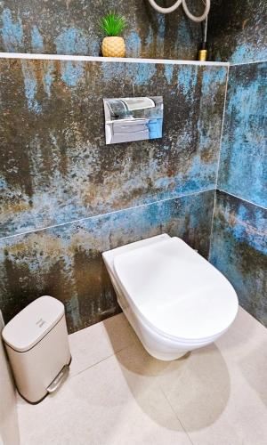 a white toilet in a bathroom with a wall at Casa Galia in Alcalalí