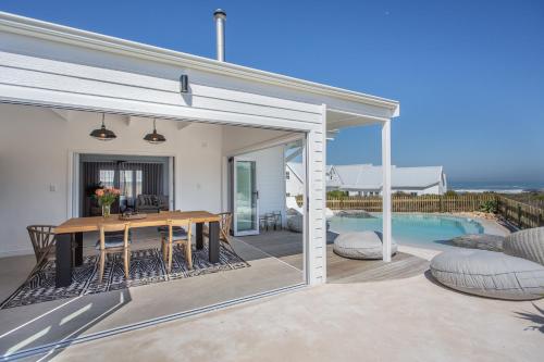 an open patio with a table and a pool at GrottoOnTheRocks in Grotto Bay