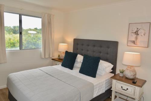 a bedroom with a large white bed with two night stands at City Stadium Apartment 3 in Townsville