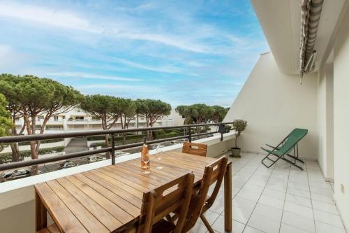 d'un balcon avec une table et des chaises en bois. dans l'établissement Plage et Golf* Clim * Parking * Spacieux * wifi Fibre * Ponant, à La Grande Motte