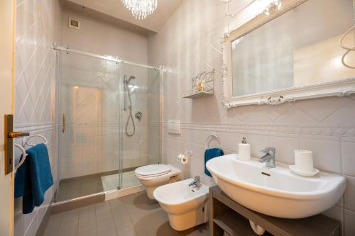 Un baño con lavabo, inodoro y ducha. en Maison Elirè - 10 passi dal mare, en Capoliveri