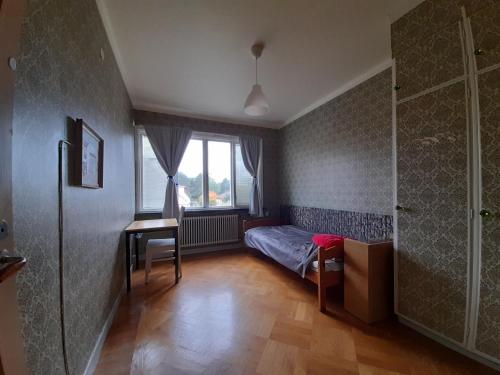 a bedroom with a bed and a desk and a window at Quite house near center in Eskilstuna