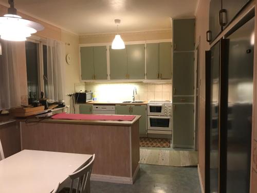 a kitchen with green cabinets and a kitchen island at Quite house near center in Eskilstuna