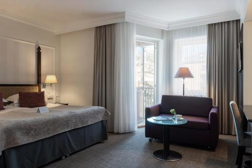 a hotel room with a bed and a chair and a table at Elite Park Avenue Hotel in Gothenburg