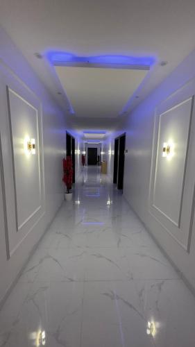 einen Flur mit lila Leuchten in einem Gebäude in der Unterkunft فندق الاقامه السعيده in Al Bad‘