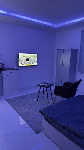 Habitación con cama, mesa y TV. en فندق الاقامه السعيده, en Al Bad‘