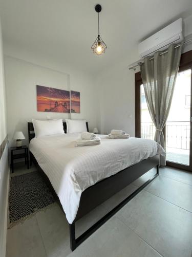 a white bedroom with a large bed and a window at Boutique At Historic Centrum 2 in Ioannina