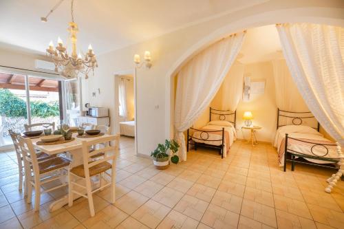 uma sala de estar com 2 camas e uma sala de jantar em Maison Elirè - 10 passi dal mare em Capoliveri