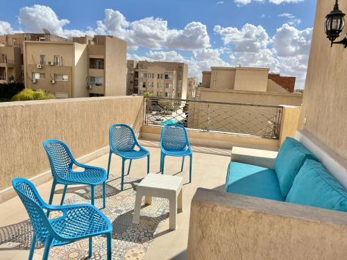 a patio with chairs and a couch on a balcony at Elegant Villa in Sheikh Zayed City, Egypt - Families Only in Sheikh Zayed