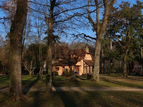 een huis in het midden van een tuin met bomen bij La Faisanderie in Saint-Florent-sur-Cher