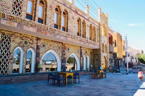 un edificio con mesas y sillas delante de él en New Abusimble 2 Hotel & Restaurant en Abu Simbel