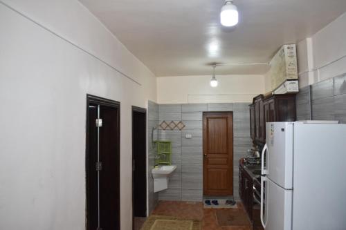 a kitchen with a white refrigerator and a sink at البيت الريفي in Jerash