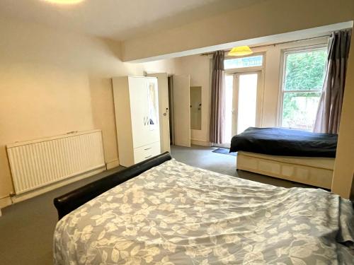 1 dormitorio con 2 camas y ventana en Earls court en Londres