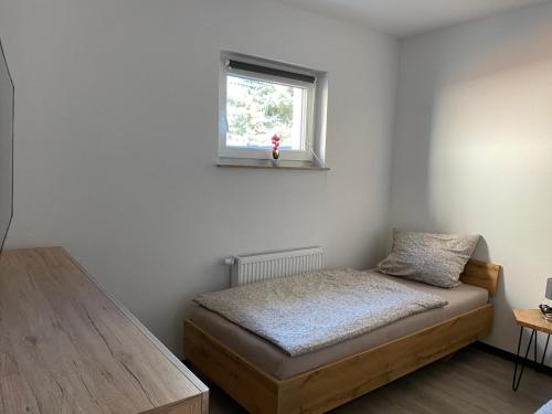 a small bedroom with a bed and a window at Alte Schlossgärtnerei Bebertal in Bebertal Zwei