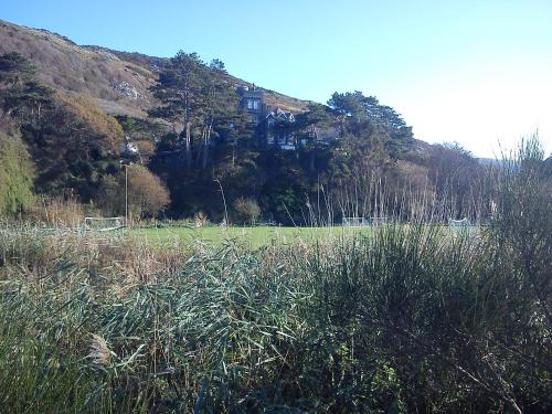 a house on top of a hill in a field at Penbryn Mynach Holiday Cottage in Barmouth