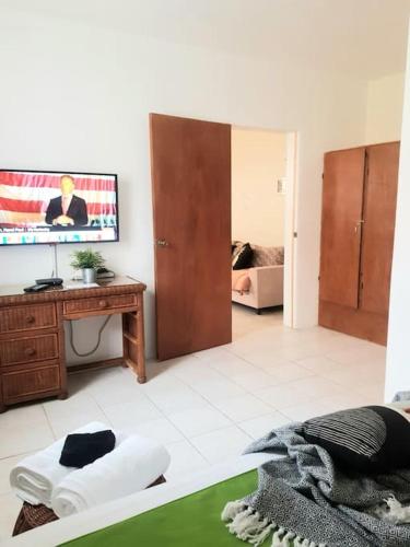 a living room with a tv and a bed at Cole Bay Apartments nearby Marinas in Koolbaai