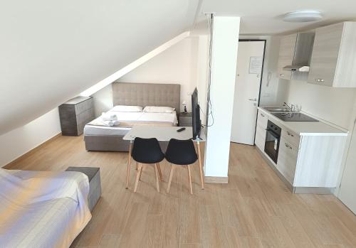 a bedroom with a bed and a desk with two chairs at Residenza delle Nazioni in Gatteo a Mare
