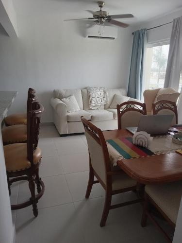 uma sala de estar com uma mesa e cadeiras e um sofá em Crisfer Punta Cana em Punta Cana