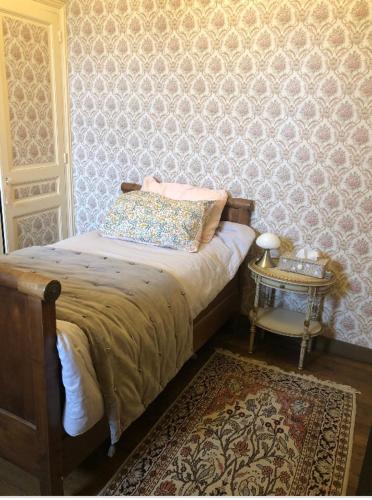 - une chambre avec un lit et une table avec un tapis dans l'établissement Château de la Franceule - la petite, à Janzé