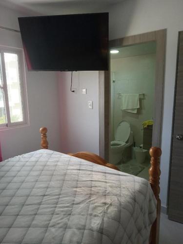 um quarto com uma cama e uma casa de banho com um WC em Crisfer Punta Cana em Punta Cana
