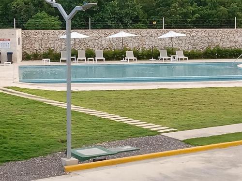 uma piscina com espreguiçadeiras e guarda-sóis em Crisfer Punta Cana em Punta Cana