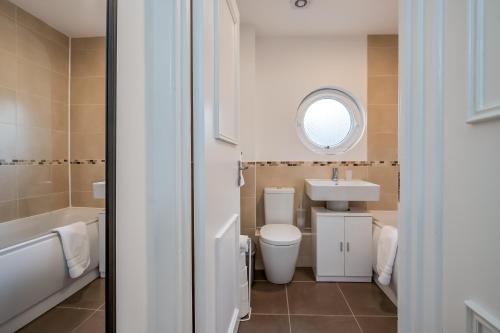 een badkamer met een toilet, een wastafel en een spiegel bij Belfast City Centre & allocated Parking by StayByNumbers in Belfast