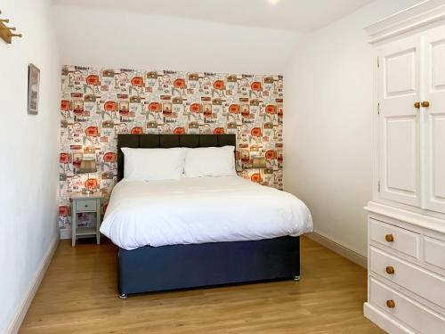 a bedroom with a bed with a wall of photos at Belton Cottage - Uk44745 in Tetford