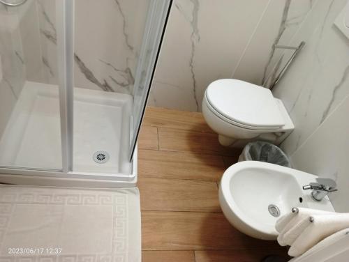 a white bathroom with a toilet and a sink at Residenza delle Nazioni in Gatteo a Mare